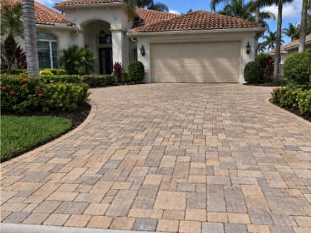 A paver driveway cleaned to an even tone from the garage to the street