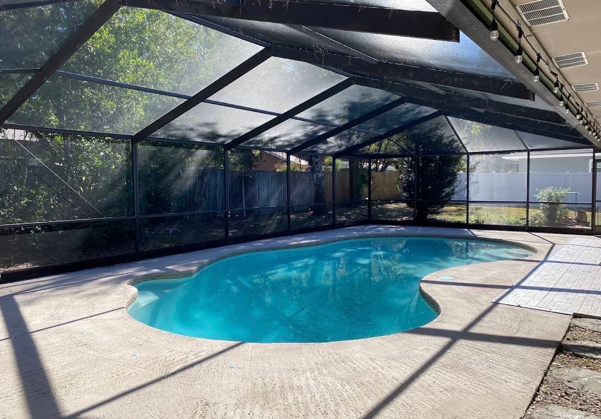 A screened pool cage over a freeform pool