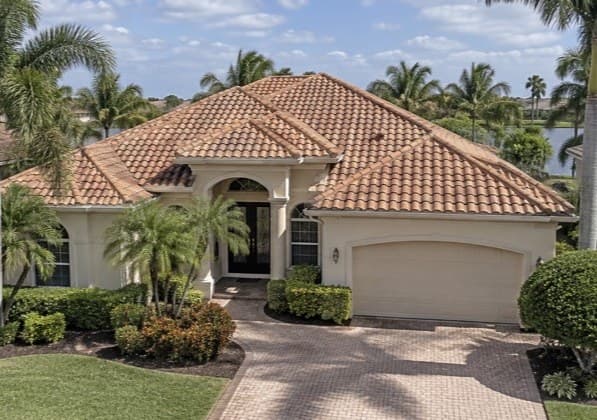 A two-story home with a clean shingle roof in afternoon sun (after)