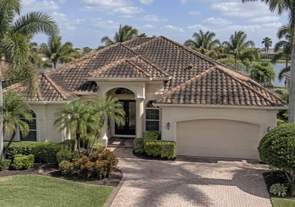 A two-story home with a clean shingle roof in afternoon sun (before)